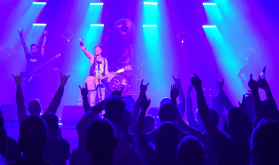 Das Archivbild der Stadt Viersen zeigt den Auftritt der Band "Abgrund hoch" beim Young-Talents-Finale 2019 auf der Bühne der Festhalle. Auf der beleuchteten Bühne sind Musiker an Gitarre und Bass zu erkennen, im Vordergrund schemenhaft das Publikum mit erhobenen Armen.