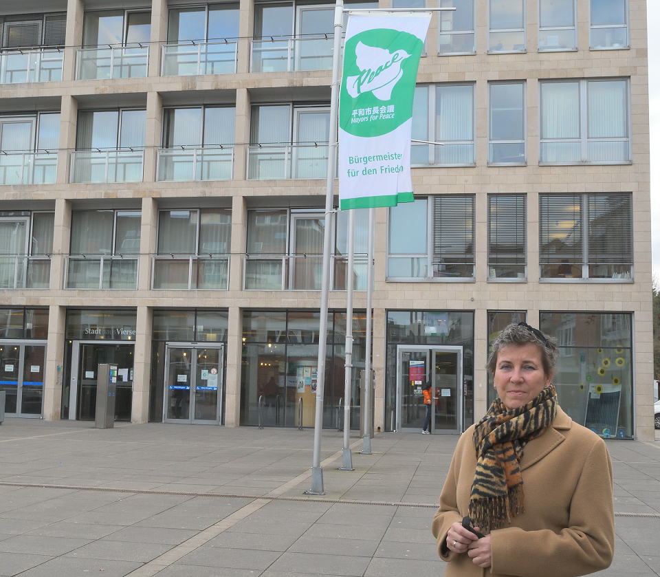 Bürgermeisterin Sabine Anemüller vor dem Stadthas, wo als Reaktion auf die russische Invasion die Mayors-for-Peace-Flagge hängt  (Foto: Stadt Viersen)