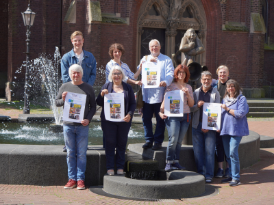 Gruppe von Menschen mit Plakaten vor Brunnen