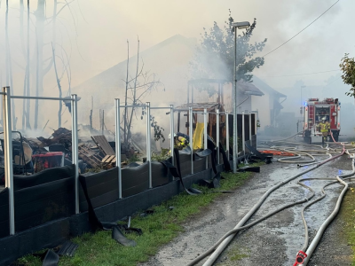 Qualmende Überreste nach Brand, Löschschläuche und ein Feuerwehrfahrzeug (Foto: Stadt Viersen – Feuerwehr)