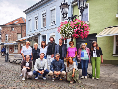 Gruppe Menschen unter Blumenampel