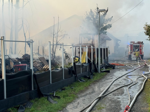 Qualmende Überreste nach Brand, Löschschläuche und ein Feuerwehrfahrzeug (Foto: Stadt Viersen – Feuerwehr)
