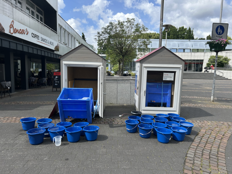 Das Bild zeigt eines der Modellhäuser mit den Resten des Eisblocks in einer Wanne und zahlreichen Wassereimern (Foto: Stadt Viersen) 